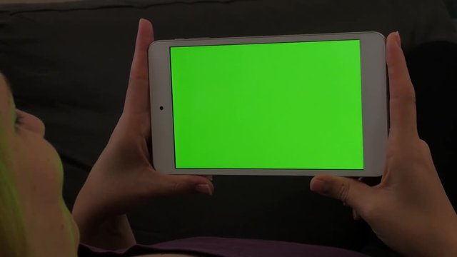 Blond woman holding green screen display tablet-pc slow pan 4K 2160p UltraHD footage - greenscreen PC tablet gadget in Caucasian female hand panning 4K 3840X2160 UHD video 