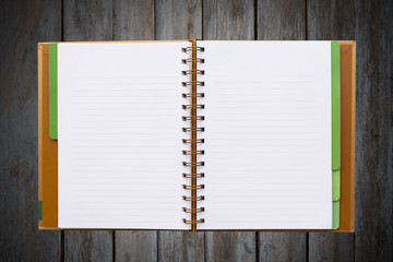 Open notebook with lined pages isolated on wood background