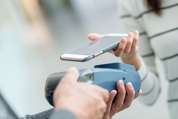 Woman using mobile phone for paying