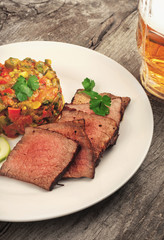 Pieces of roast beef with a glass of lager