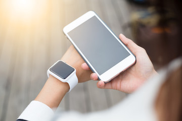 Woman connecting cellphone and smartwatch