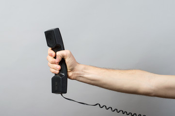 Telephone receiver in hand isolated on grey background