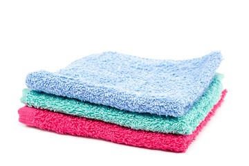Stack of colored towels on white.