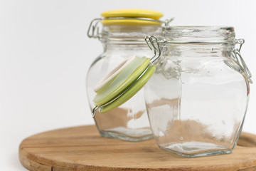 Two empty glass jars on the wooden board