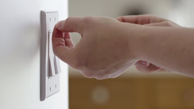 Close up of a hand installing a typical light switch cover in the USA.  Originally recorded in 4K