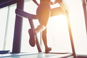 Fitness girl running on treadmill