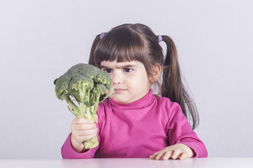 Little girl making a funny face refusing to eat her vegetables