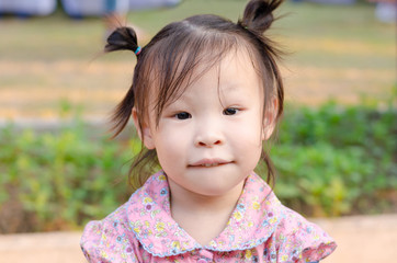 Little Asian girl smiling in park