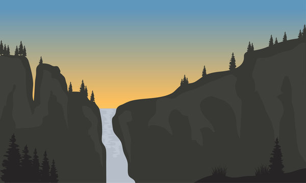 Silhouette of waterfall at sunset