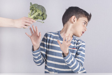Little boy refusing to eat his vegetables