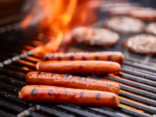 Keuken foto achterwand Grill / Barbecue smakelijke hotdogs koken op de grill met hamburgers