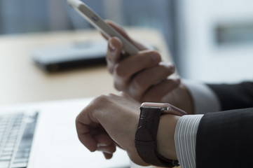 Businessman is mastering the smart watch and smartphone