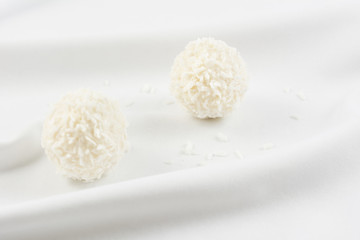 Fototapeta na wymiar White chocolate candy coconut truffles on white material