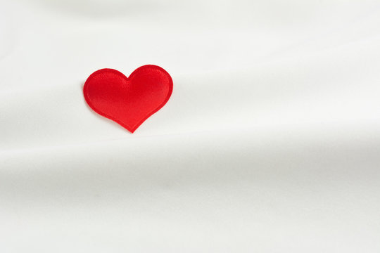 Red heart on beautiful white material. Valentine day background