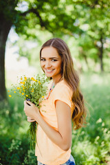 Naklejka premium young beautiful brunette girl in a straw hat with red lips, beautiful smile and white teeth, posing in the Park t spring flowers in their hands, tenderness, happiness, mood, outdoor portrait, close up