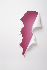 Paper ripped and torn to reveal pink wall