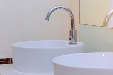 white basins in bathroom interior with granitic tiles
