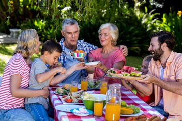Multi- generation family offering food at breakfast 