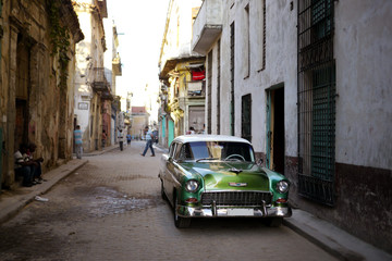 street scene in havana, cuba with old car
