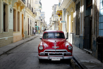 street scene in havana, cuba with old car