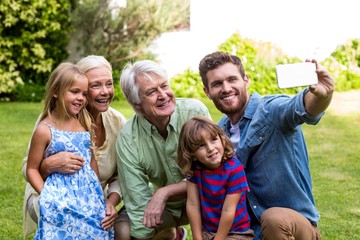 Happy father taking selfie with family in yard