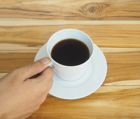 hand holding white cup of coffee