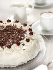 Black forest cake decorated with whipped cream and cherries