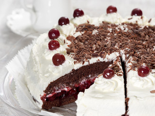 Black forest cake decorated with whipped cream and cherries