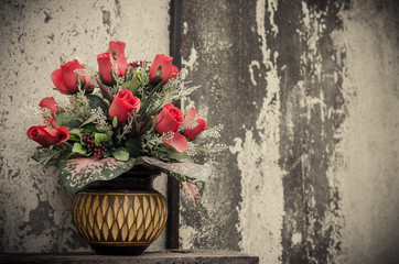 bunch of artificial roses in old retro colors over gray backgrou
