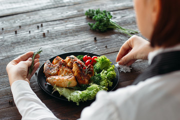 Decoration of chicken wings on wooden table. Chief prepares grilled spicy chicken with fresh...