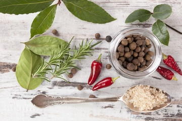 Bay leaves, spice and condiments wooden background.