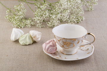 Чай в фарфоровой чашке и меренги 