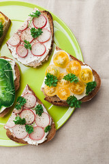 Vegetarian sandwiches with yellow tomatoes, red radishes, green pepper and sprouts