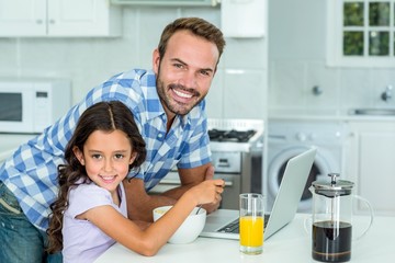 Happy man standing by daughter in kitchen at home