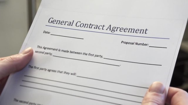 Blank General Contract Agreement Form In Male Hands. A contract is a voluntary arrangement between two or more parties that is enforceable at law as a binding legal agreement.