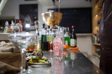 Fototapeta na wymiar Bartender coocks cocktail behind a bar counter