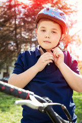 Fototapeta na wymiar Boy putting on a bike helmet