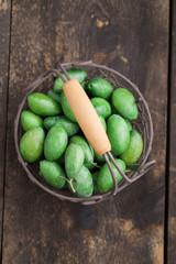 Fresh green olives in little basket on wooden table