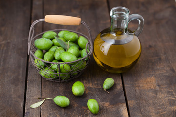 Fresh green olives with olive oil on wooden table