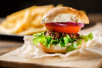 Homemade burger with french fries on wooden table