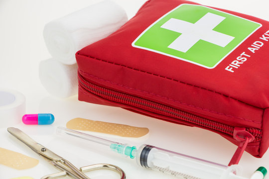 First aid kit with medical equipment, on white background