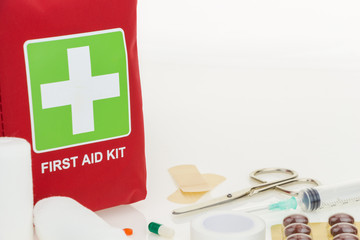 First aid kit with medical equipment, on white background with copy-space