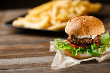 Homemade burger with french fries on wooden table