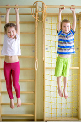 Kids playing and hanging on horizontal bar © Vitalinka