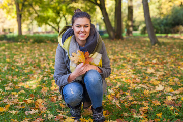 Young girl is collecting colorful leaves for a bouquet. Autumn t