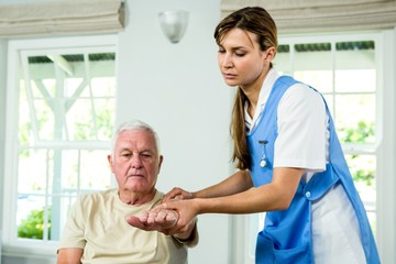 Obraz premium Focused nurse assisting senior man