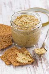 homemade mustard in a glass jar and crackers, vertical