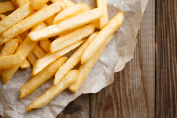 Fresh french fries on wooden background