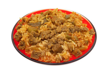 Rice peppers and beef chunks on a red plate