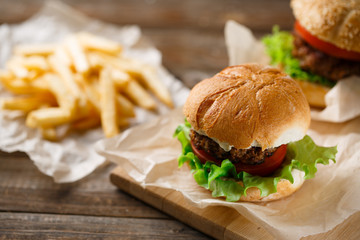 Homemade hamburgers and french fries on wooden table
